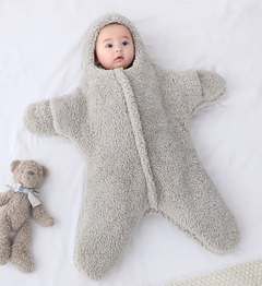 Baby Quilt - Soft & Cozy Newborn baby wrapped in a plush, pink snowsuit on a soft surface.