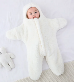 Baby Quilt - Soft & Cozy Newborn baby wrapped in a plush, pink snowsuit on a soft surface.