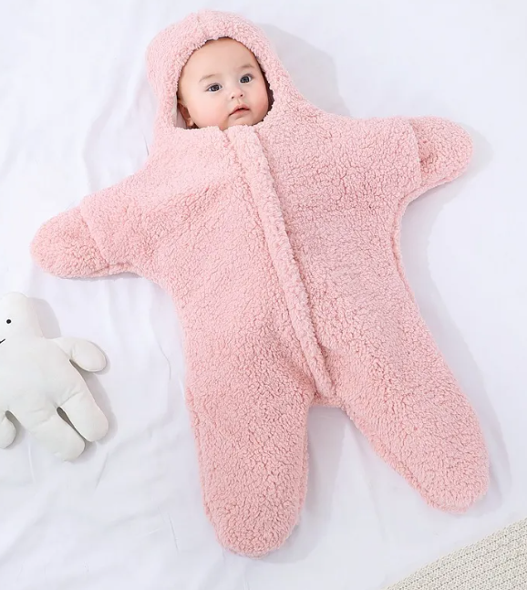Baby Quilt - Soft & Cozy Newborn baby wrapped in a plush, pink snowsuit on a soft surface.